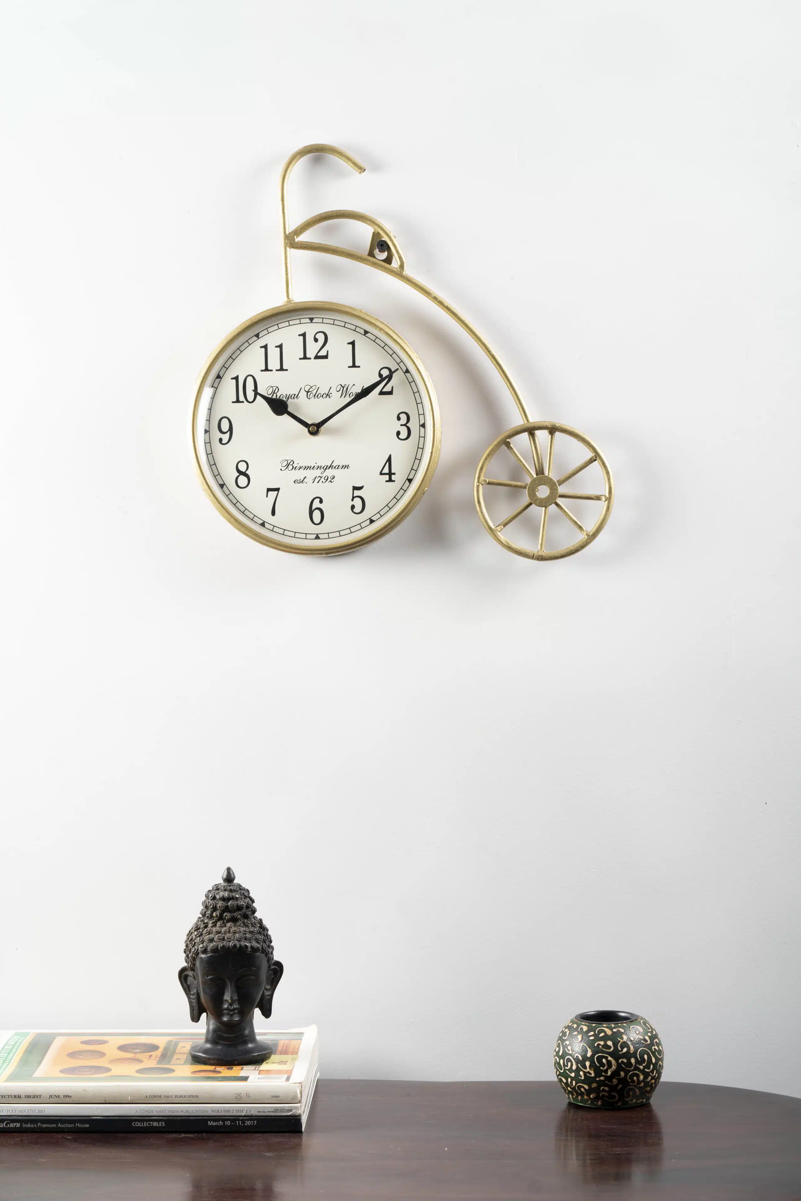 Ancient Wheel Metal Abstract Wall Clock with brass-finish penny-farthing bicycle design and Roman numeral dial by Vedas Homes