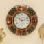 Srinika Handpainted Wooden Wall Clock with black Mughal miniature frame, gold scroll-work and royal court artwork by Vedas Homes