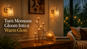 Cozy monsoon mood lighting featuring handcrafted metallic candle holders, a bird-themed candle stand, and warm glass wall sconces in a rainy living room setting. Text reads: Turn Monsoon Gloom Into a Warm Glow.